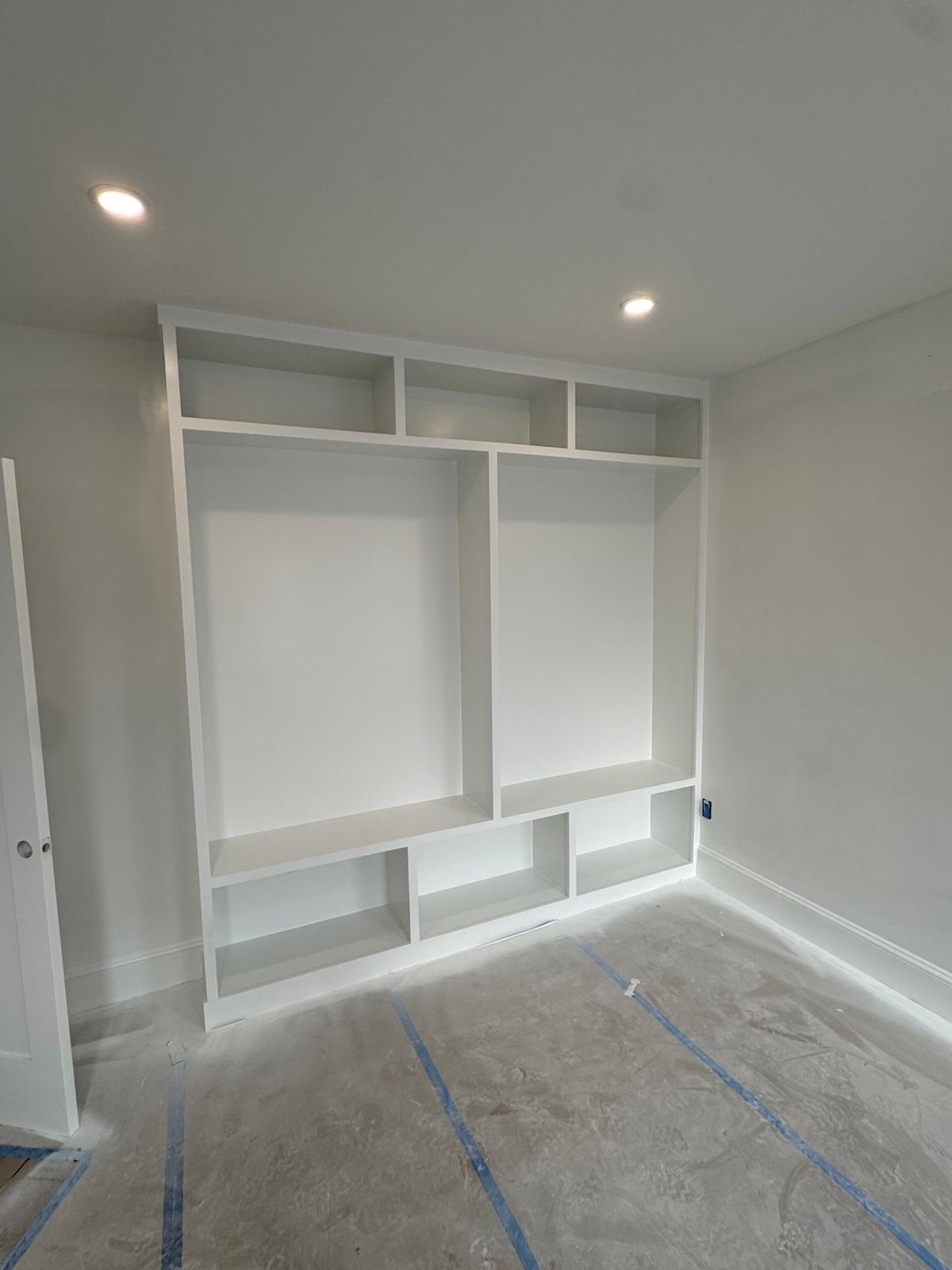 Custom white built-in shelving and storage freshly painted